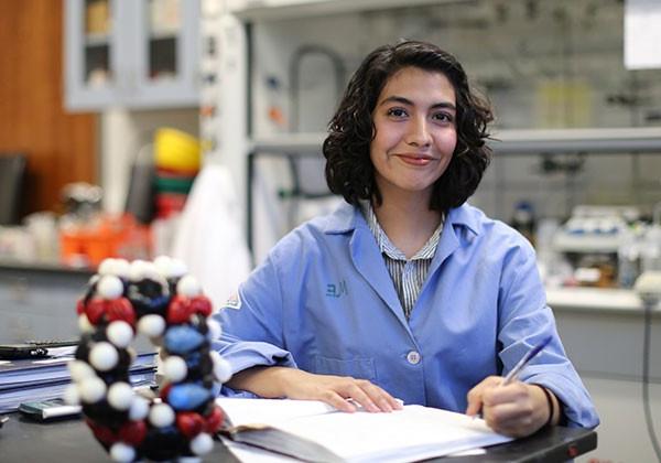 Latina student in blue labcoat in a lab