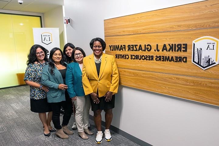 Group of people standing in front of a sign.